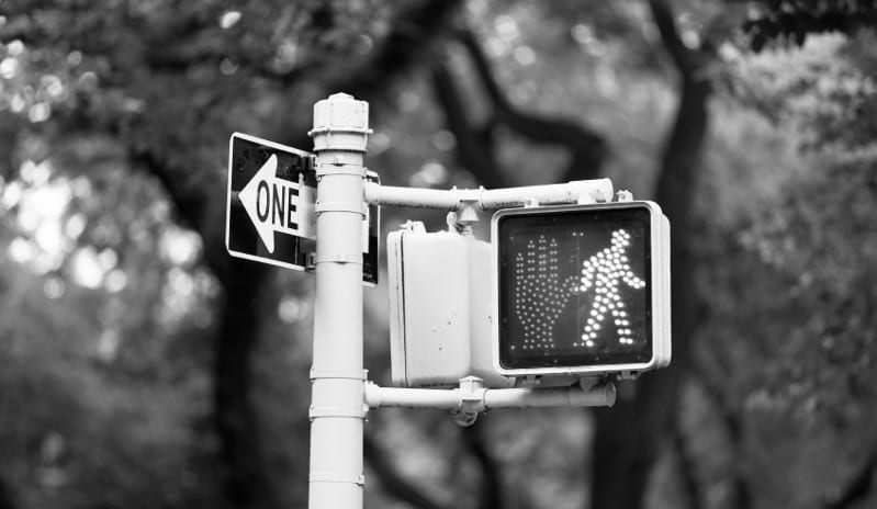 A traffic light with a pedestrian sign on it.