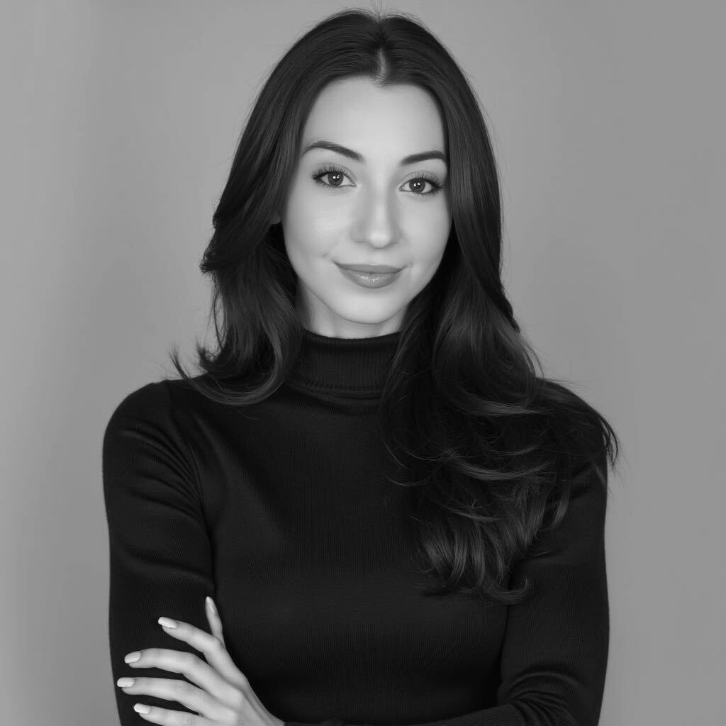 Confident woman in black turtleneck with arms crossed, smiling.